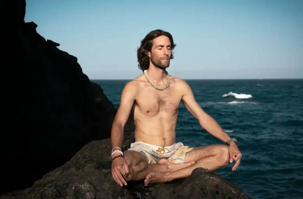 A person is meditating on the sea